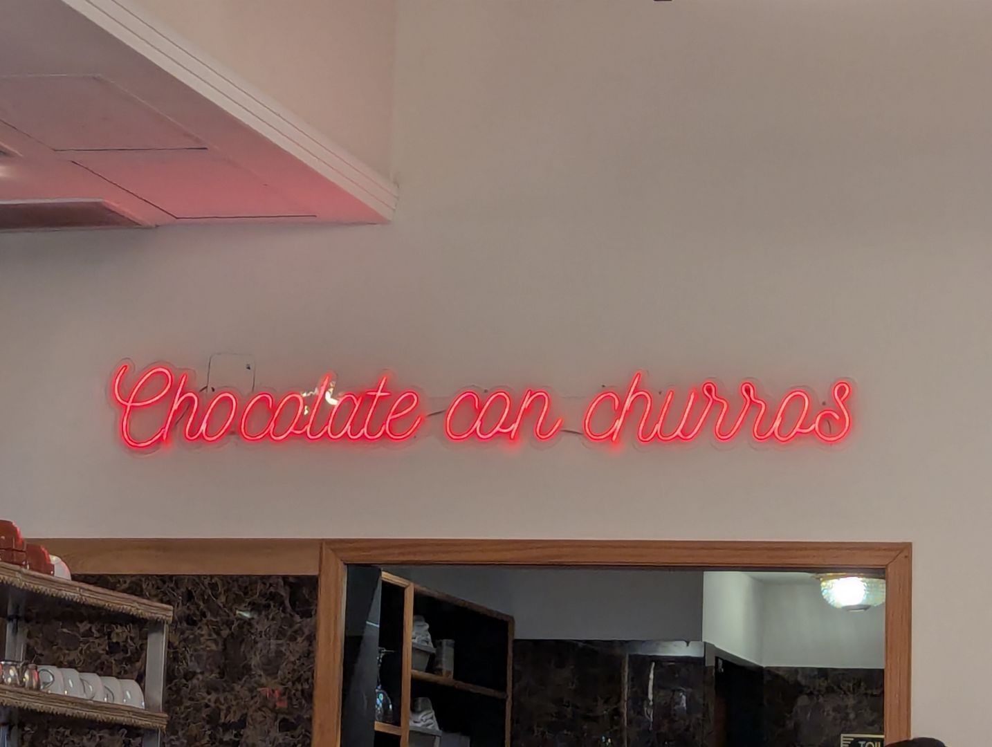Neon sign promoting cocoa beverage with pastry (chocolate con churros) atCABA